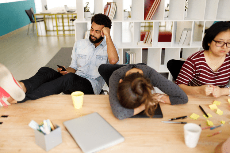 Três funcionários, um homem e duas mulheres aparentando frustação por conta de ruídos na comunicação.